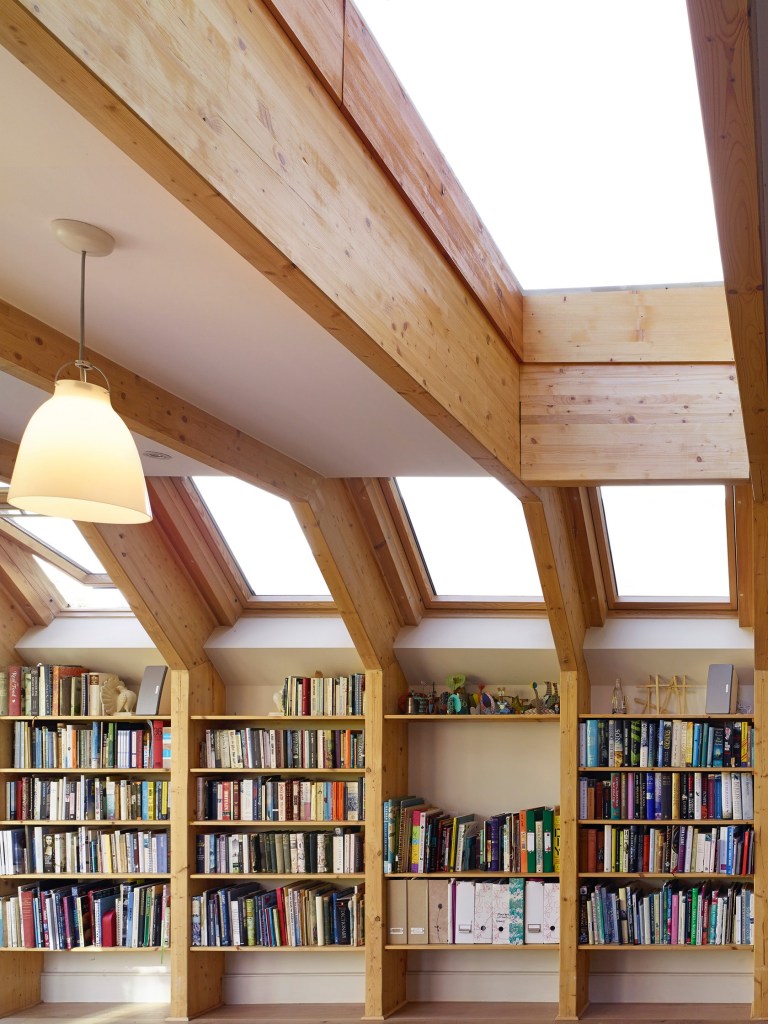 Sala de jantar integrada a biblioteca de madeira