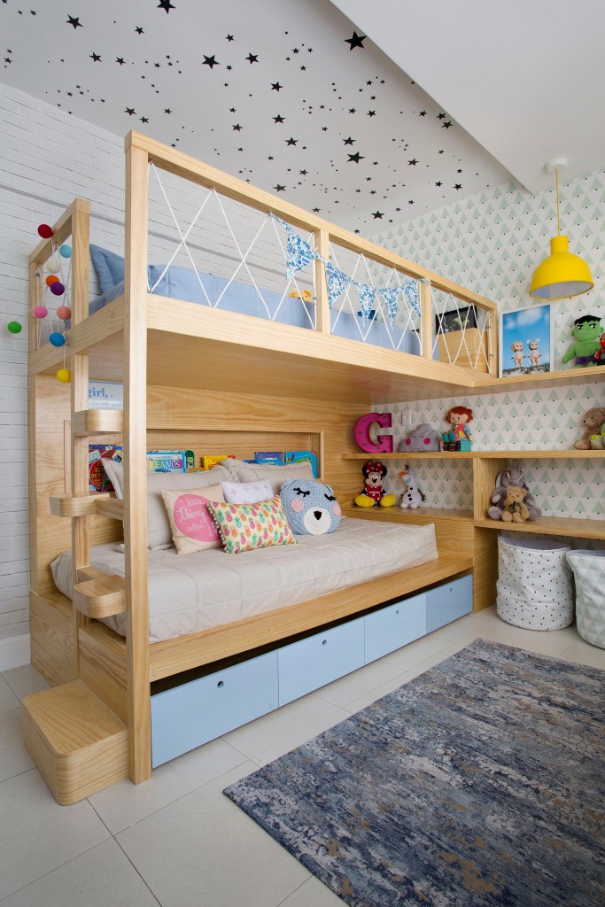 Cama beliche em quarto infantil com papel de parede de estrelas no teto