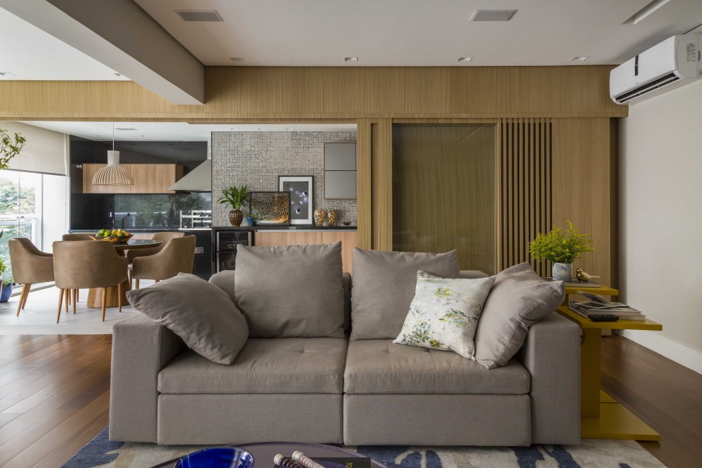 Apartamento com marcenaria versátil que divide e integra espaços