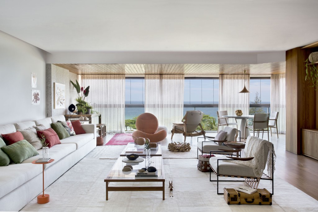 Emoldurada na janela, a praia traz um motivo extra para curtir este apartamento, que privilegia tons neutros e design nacional