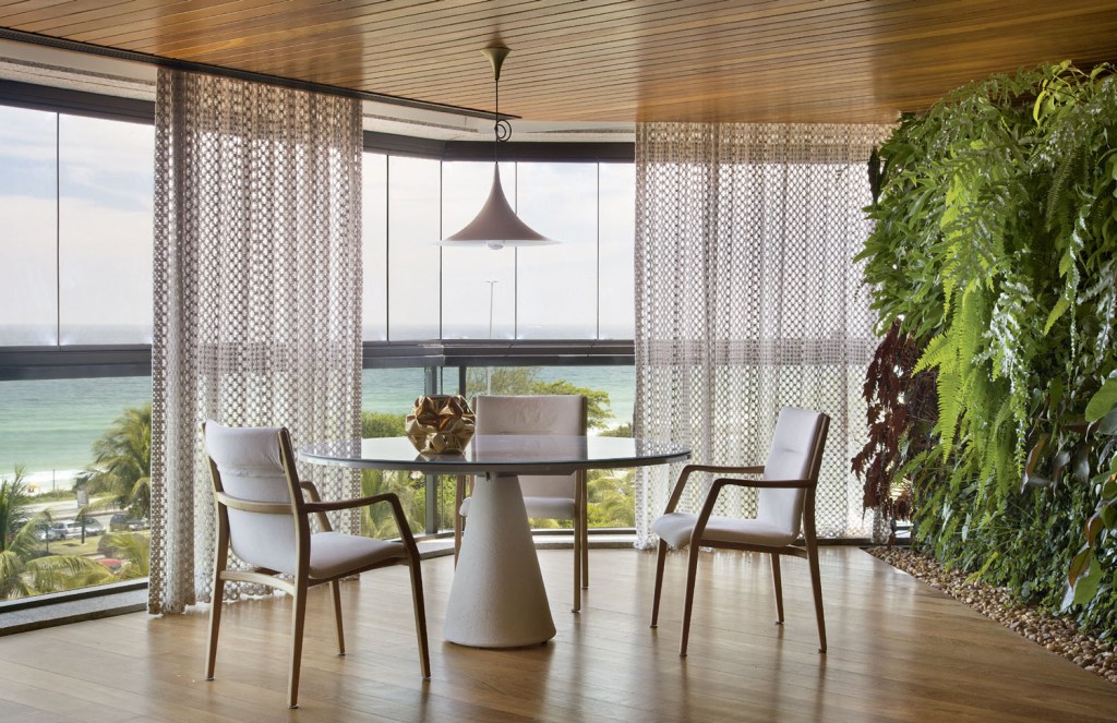 Emoldurada na janela, a praia traz um motivo extra para curtir este apartamento, que privilegia tons neutros e design nacional